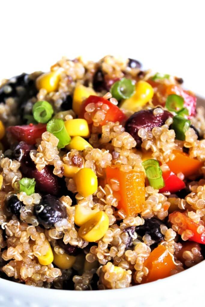 A white bowl filled with Vegan bean salad -southwestern style rainbow salad.