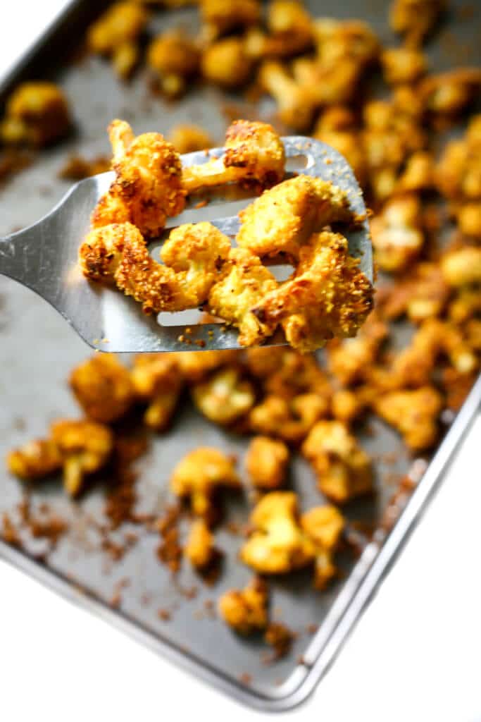 A cookie sheet filled with baked cauliflower bites.