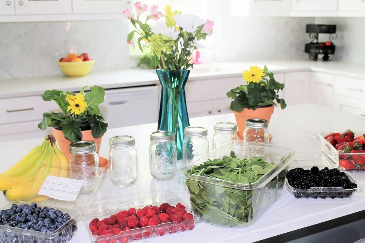 Fruits and vegetables laid out on a counter top to prep smoothies.