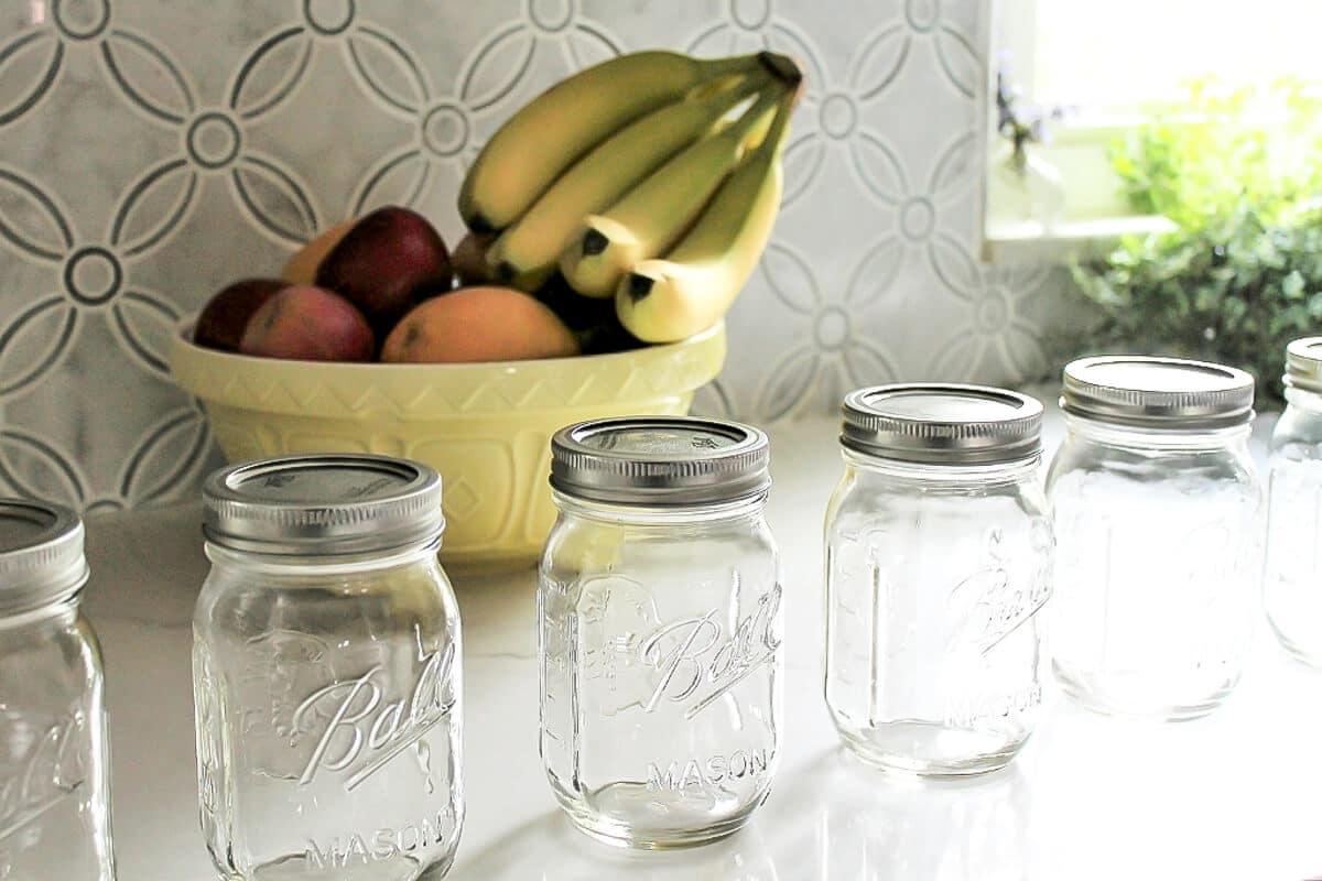 Mason jars lined up to prep for make ahead smoothies.