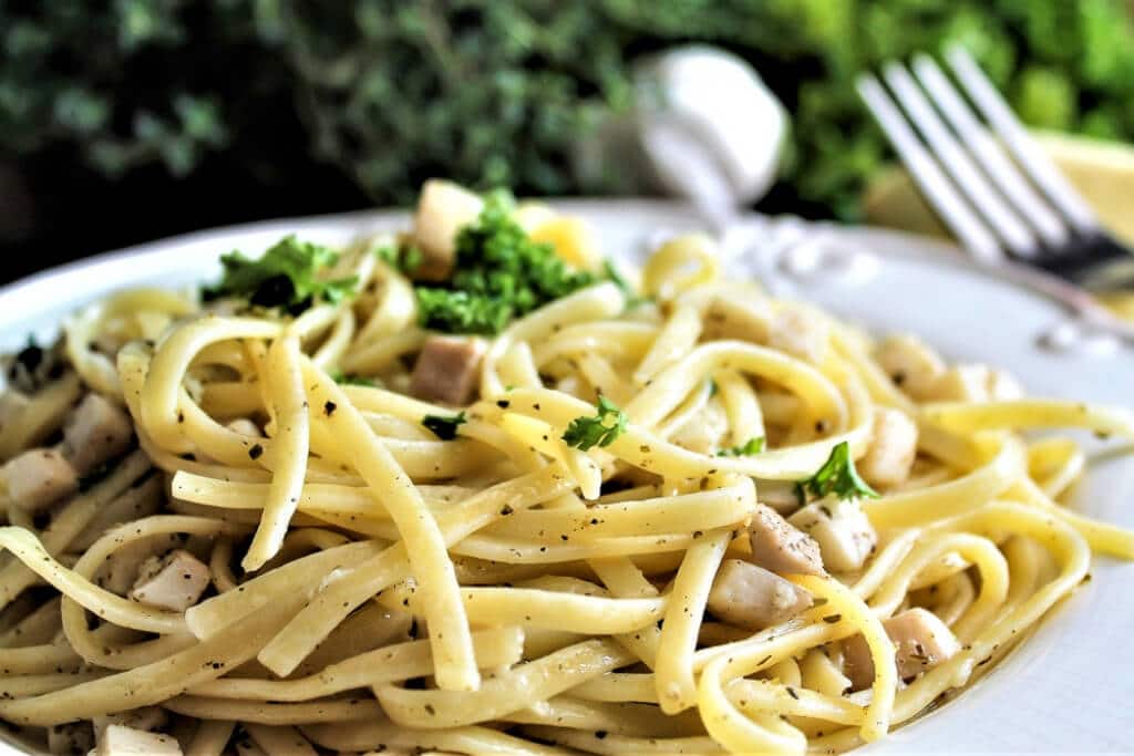 A white plate full of vegan linguine with "clam" sauce.