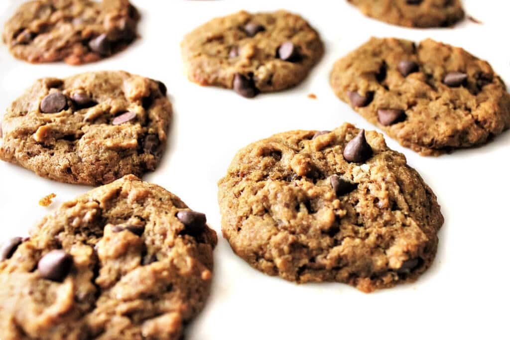 Vegan carob chip cookies cooling on a white counter top.