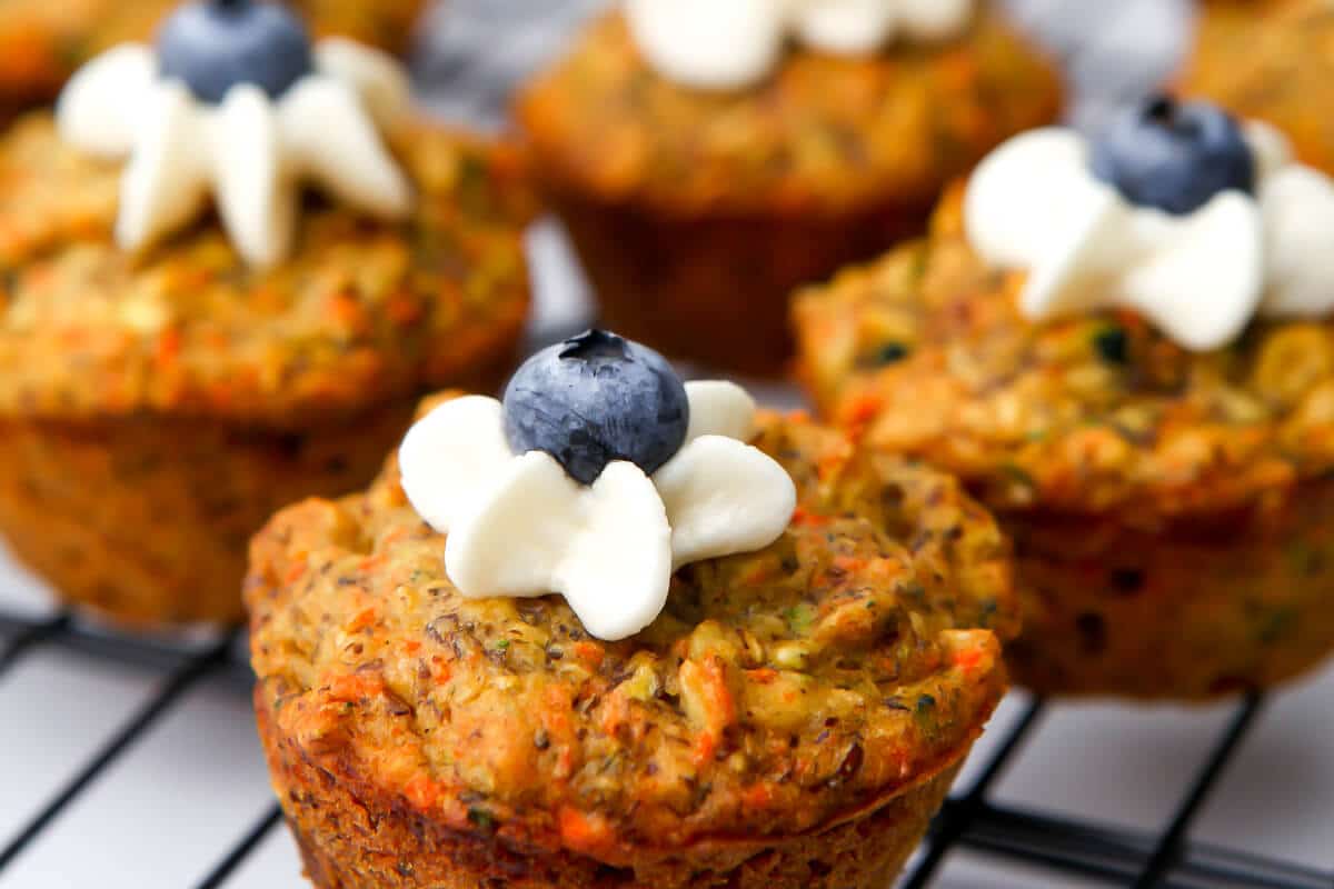 A close up of healthy zucchini carrot muffins on a cooling rack.