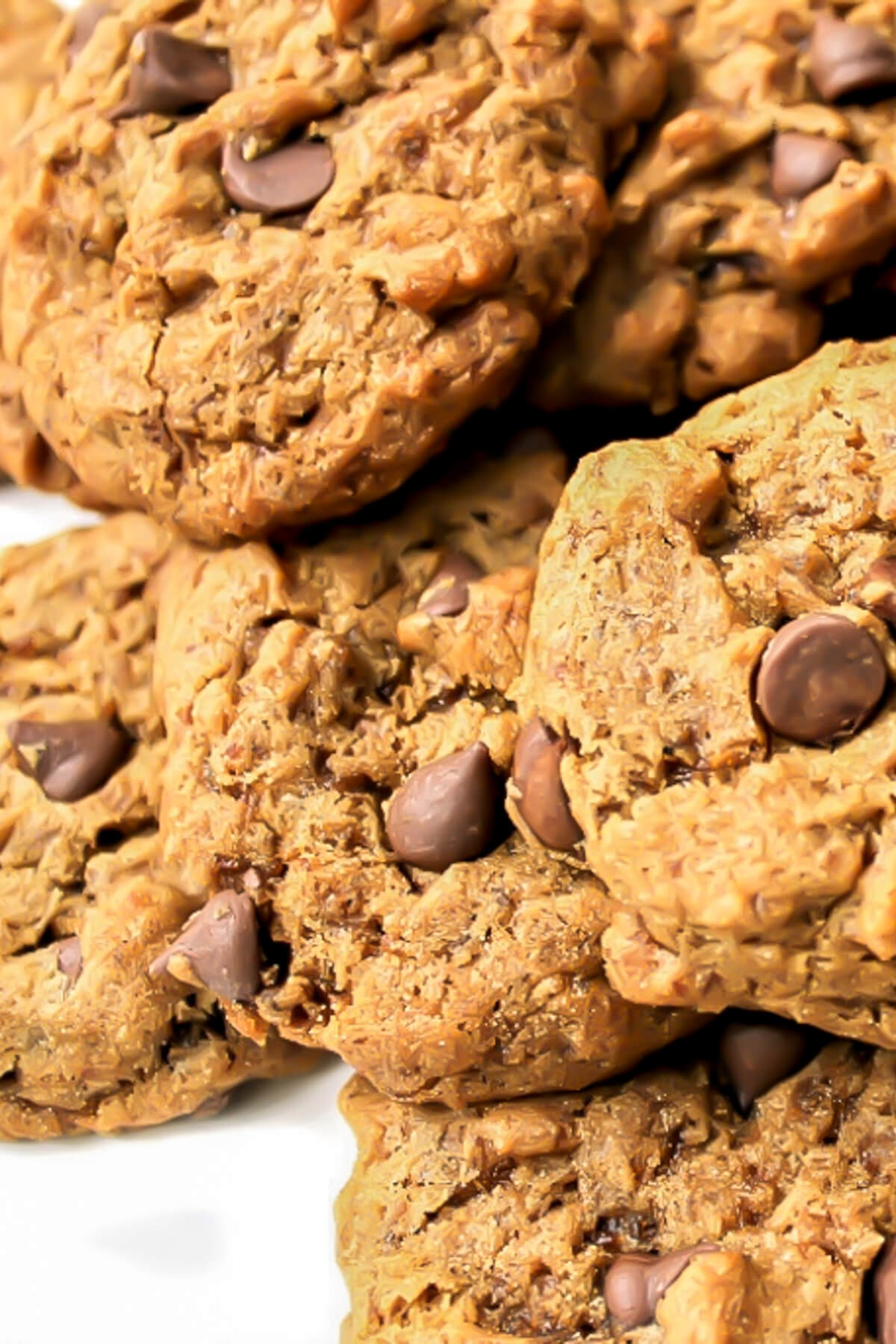 A close up of a pile of carob chip cookies.