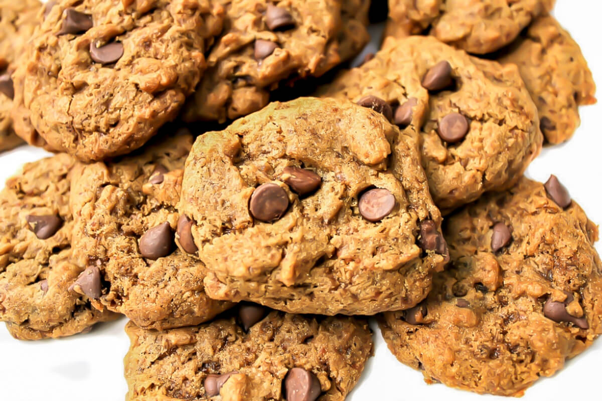 A pile of carob chip cookies on a white plate.