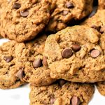 A pile of vegan carob chip cookies on a white plate.
