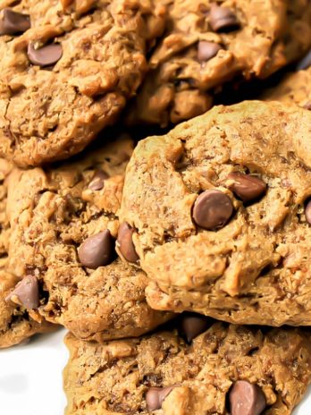 A pile of vegan carob chip cookies on a white plate.
