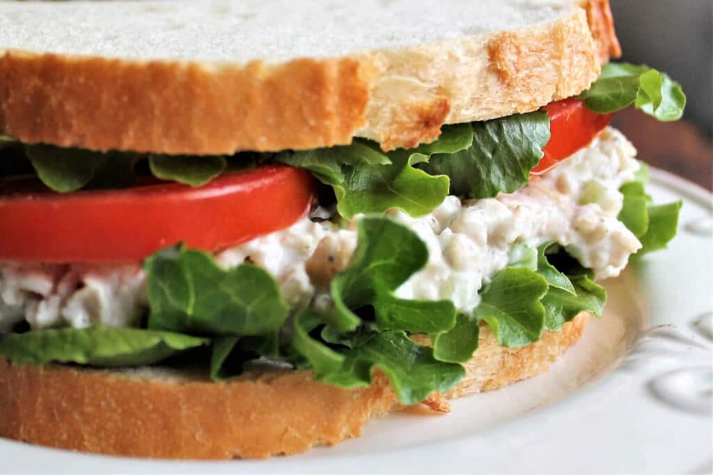 A vegan tuna salad salad sandwich with lettuce and tomatoes.