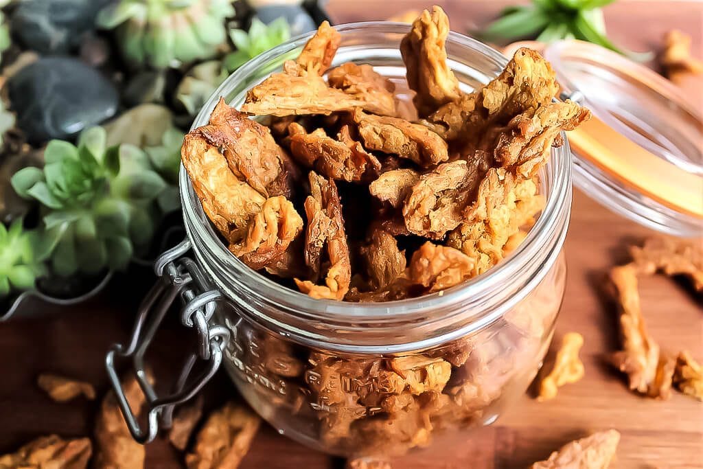 A glass jar filled with homemade vegan jerky made from soy curls.