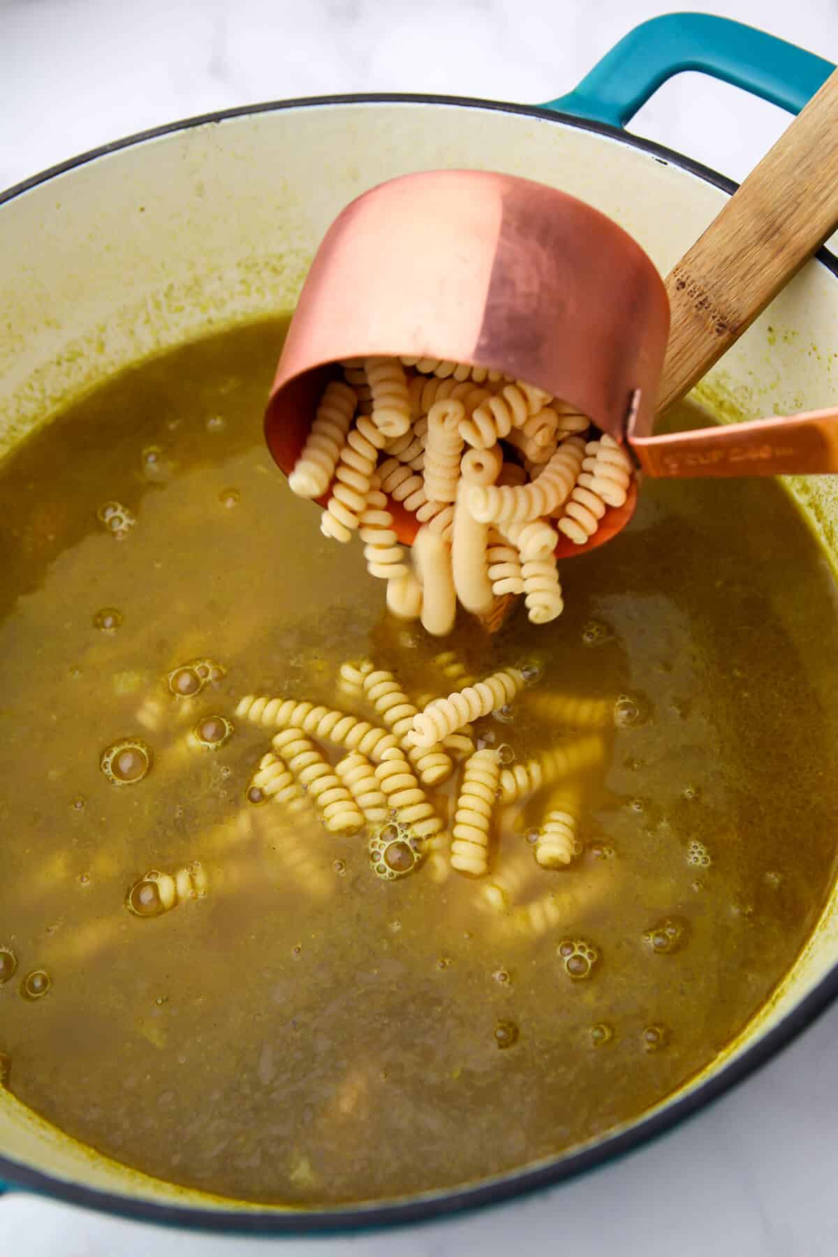 Adding noodles to vegan chicken noodle soup.