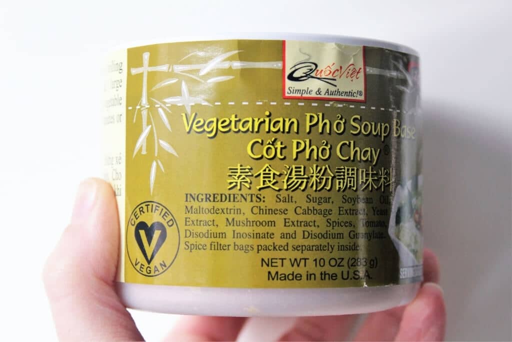 Someone holding a jar of vegan Pho Soup mix.