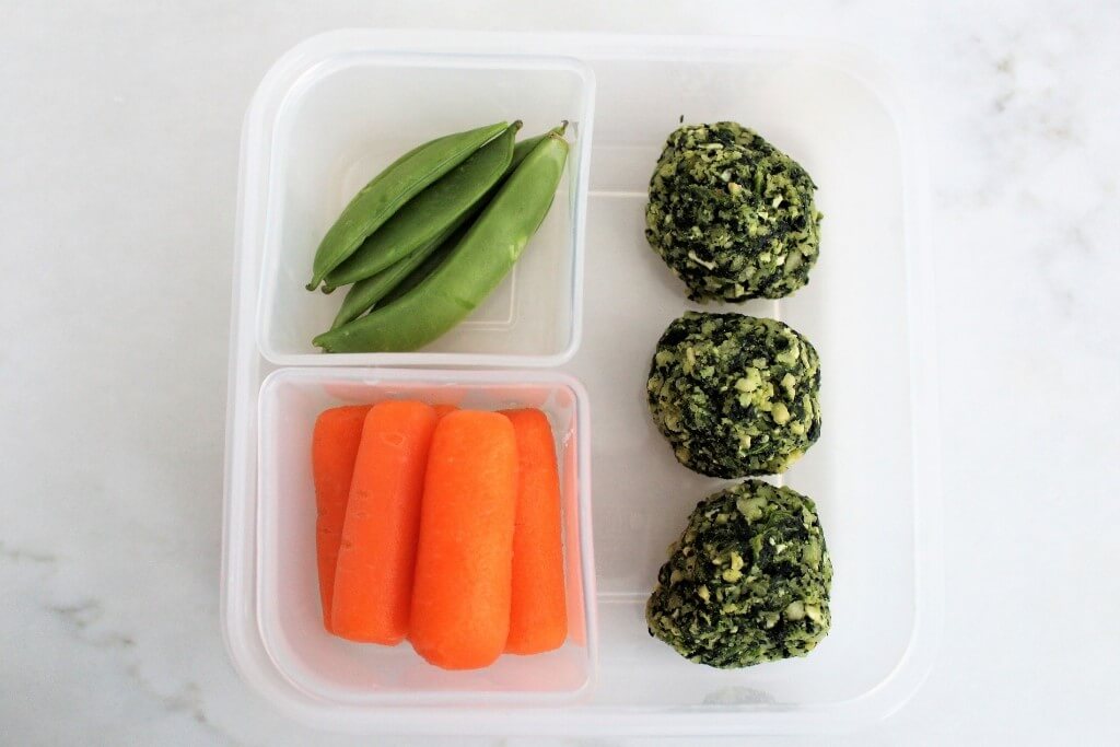 Lunch box container with vegan spinach balls.