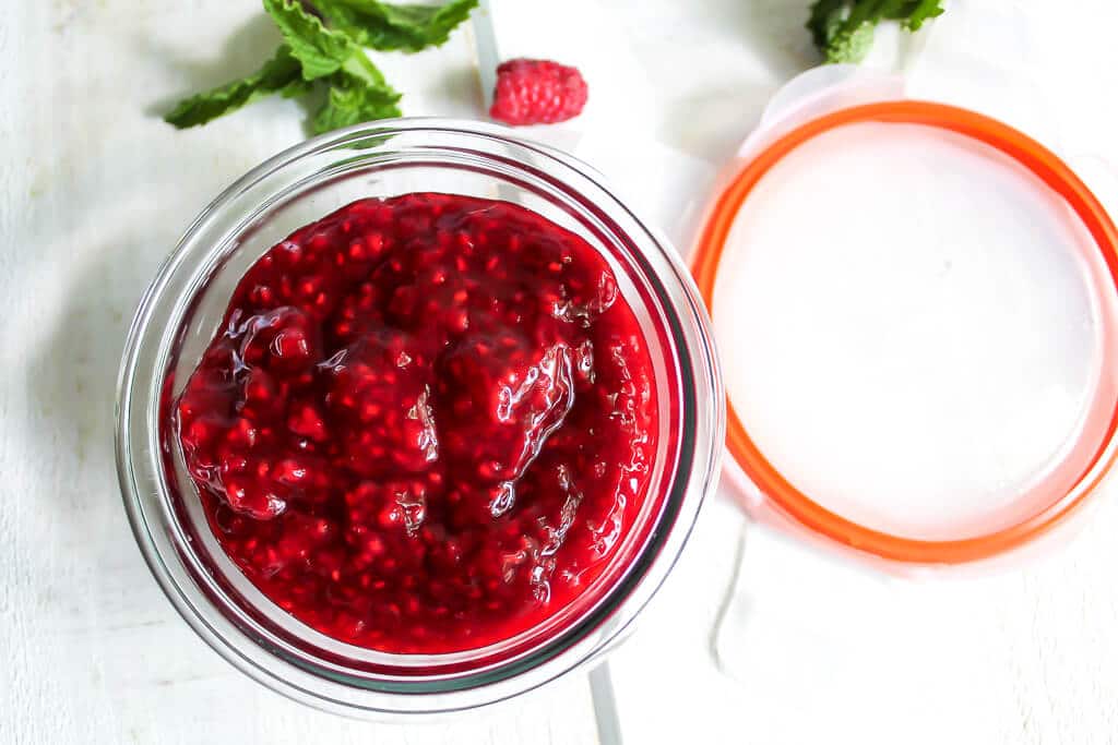 Berry compote in a glass container to be sealed and put in the fridge.