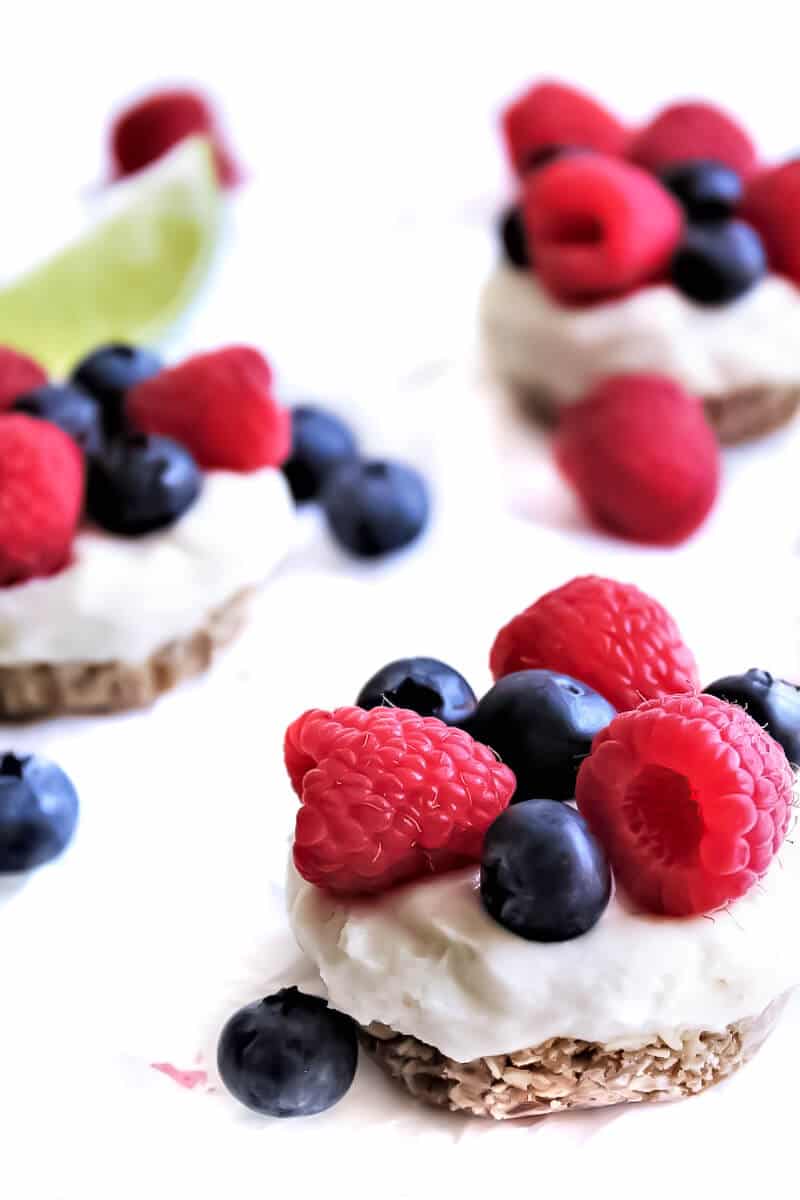 Vegan cheesecake bites topped with blueberries and raspberries.