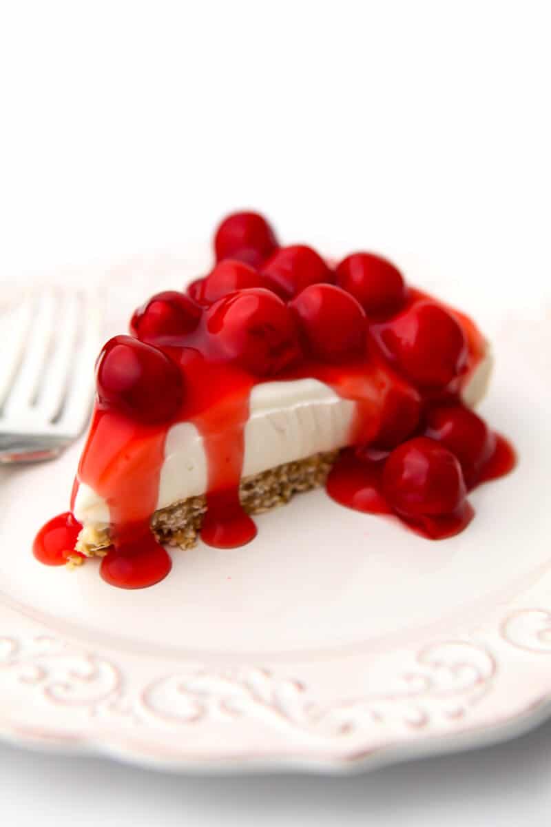 A vegan no-bake cheese cake made with cherry pie filling on top.