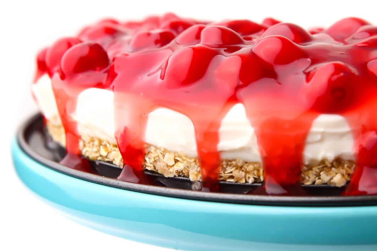 A vegan cherry cheesecake on a blue plate.