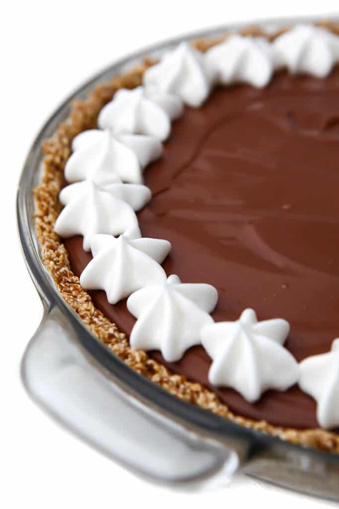 A vegan chocolate cream pie with a border of vegan whipped cream around the edge.
