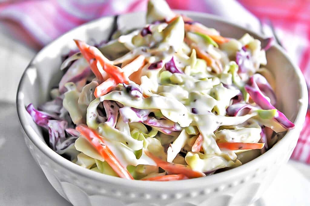 A white bowl filled with vegan coleslaw made with homemade vegan mayo.