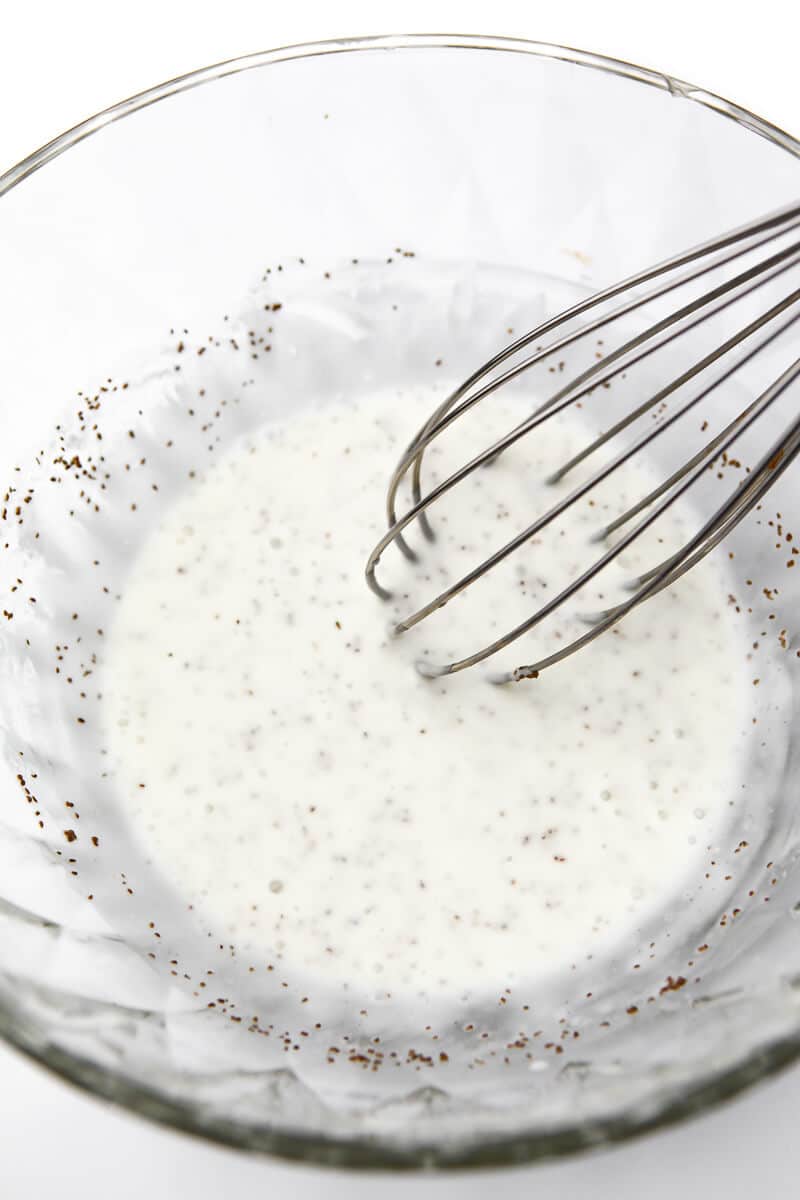 Vegan mayo, vinegar, sugar, and celery seed being mixed together to make the coleslaw dressing.