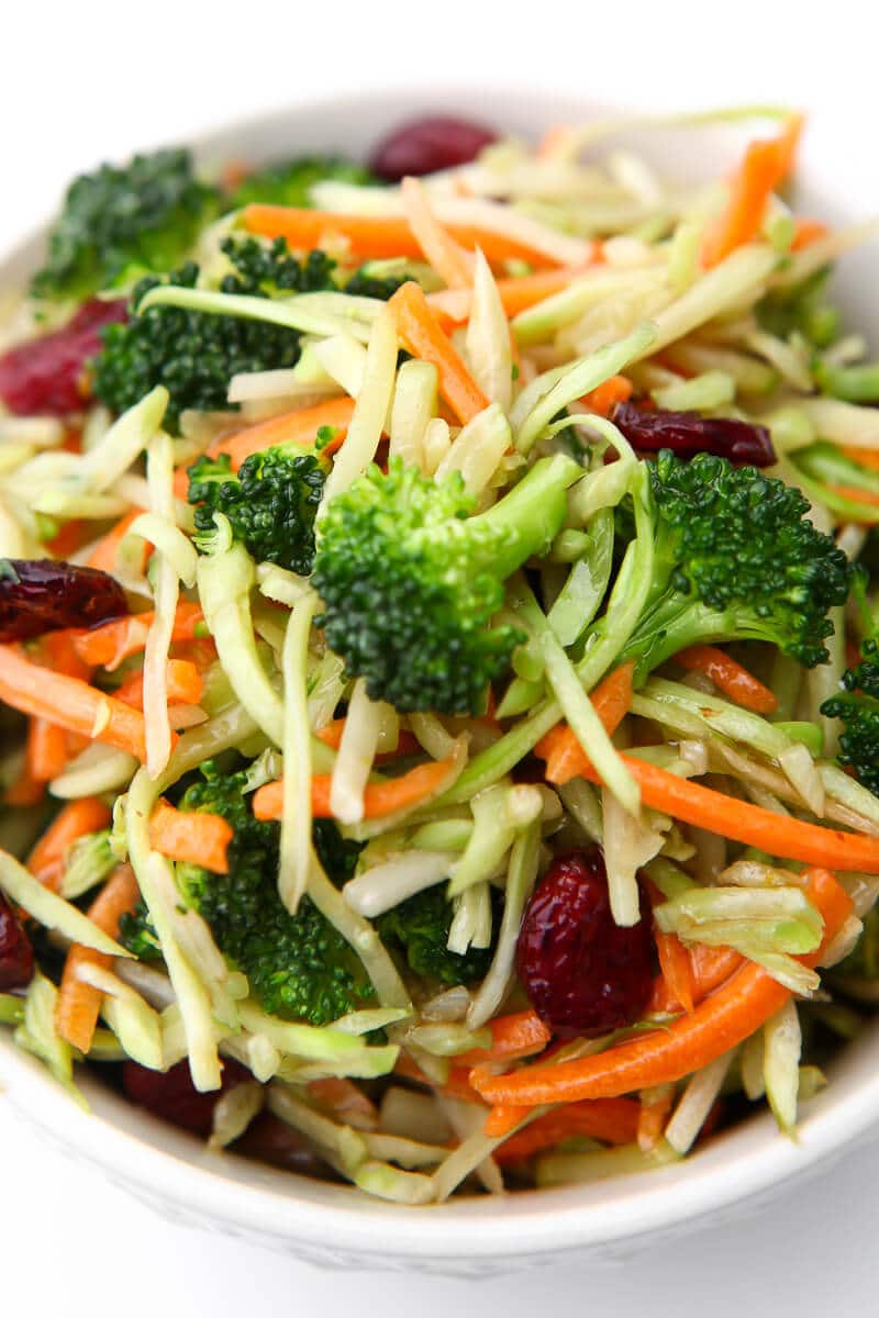 A top view of a bowl of broccoli salad with broccoli slaw and cranberries.