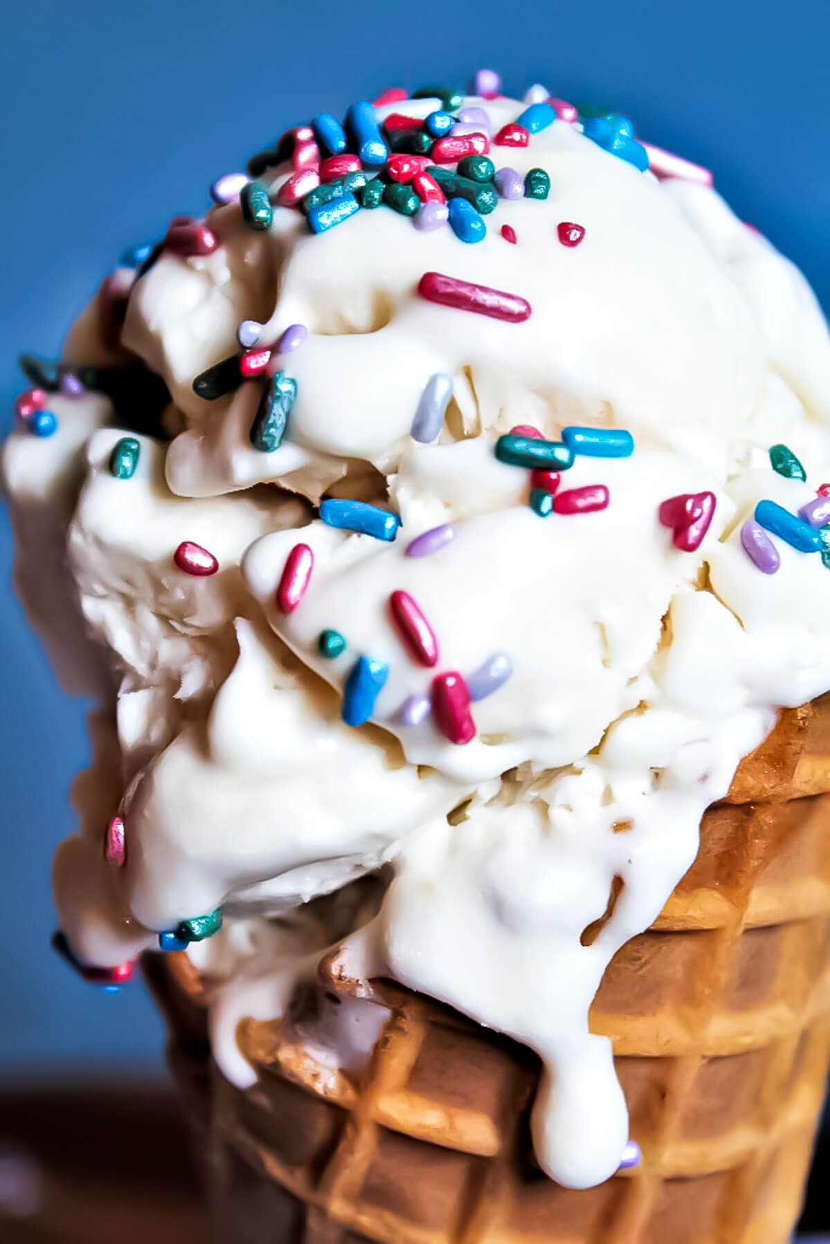 Vegan vanilla aquafaba ice cream on a sugar cone with sprinkles.