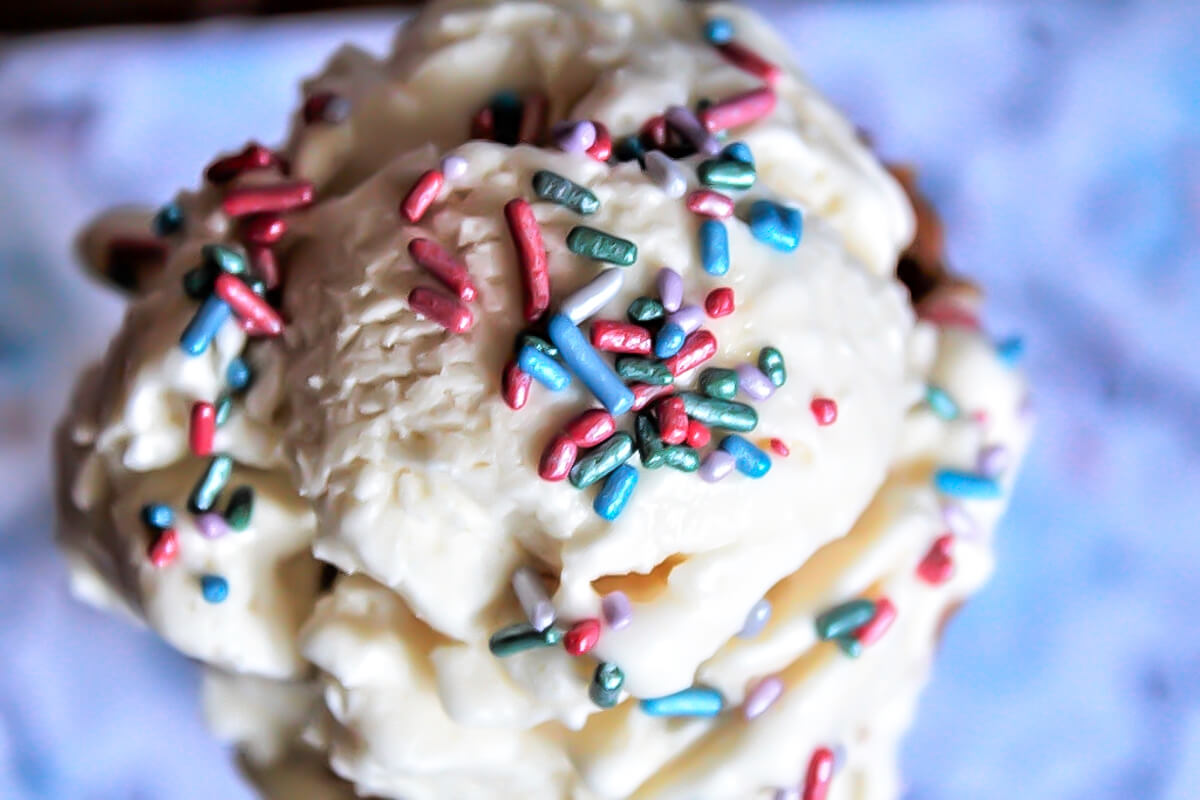 A top view of an aquafaba ice cream cone with sprinkles on top.