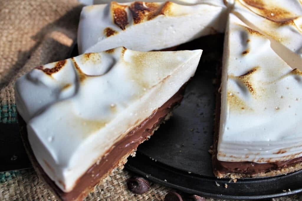 A slice being cut out of a gluten free vegan s'more pie made with tofu and aquafaba.