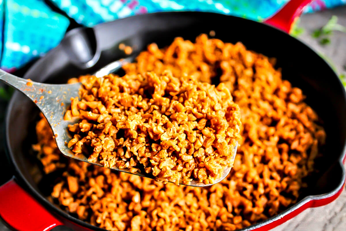 Homemade Soyrizo cooking in a red iron skillet.