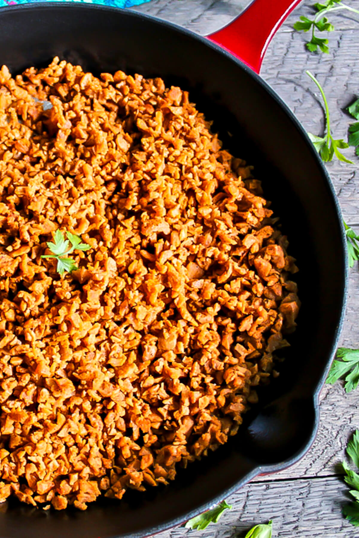 A top view of a red skillet filled with vegan soy chorizo made from TVP.