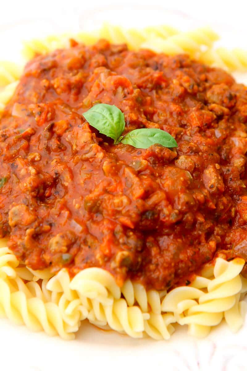 A close up of a plate of pasta covered in vegan bolognese sauce.