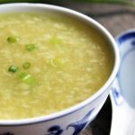 A close up of vegan egg drop soup in a white bowl.