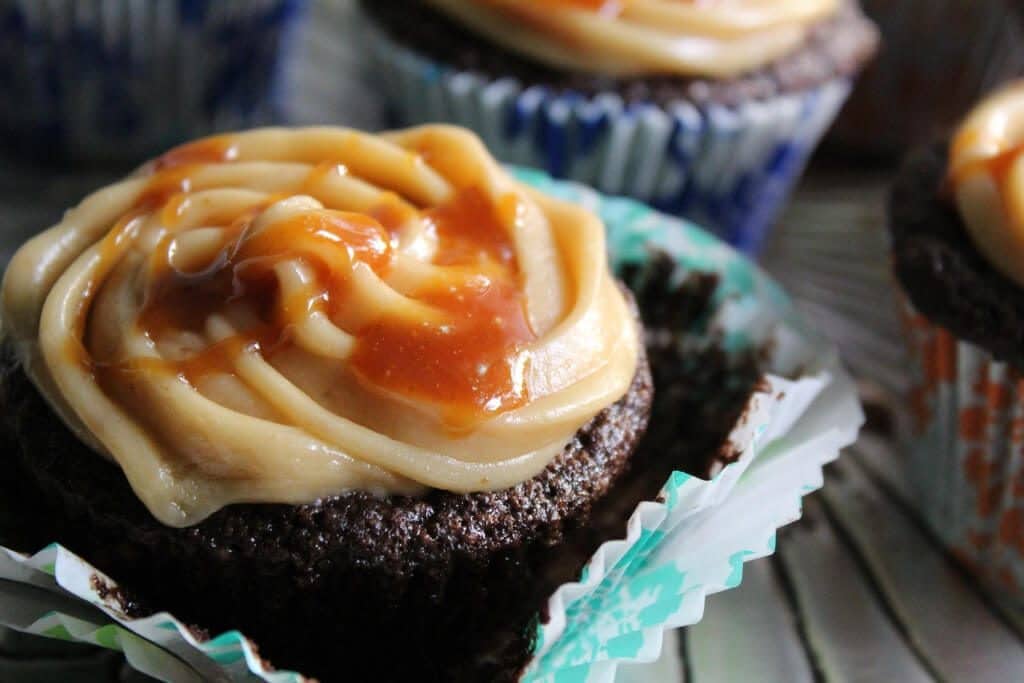 A close up of vegan caramel frosting on a cupcake with salted caramel drizzled on top.