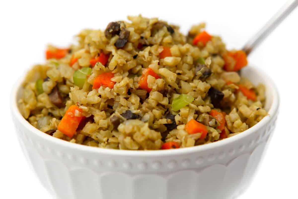 A bowl filled with gluten-free stuffing made from riced cauliflower.
