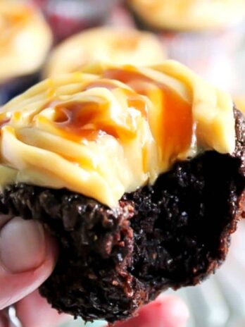 A close up of a gluten free vegan chocolate cupcake with a bite taken out of it.