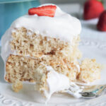 A close up of a slice of vegan angel food cake with vegan whipped cream on top.
