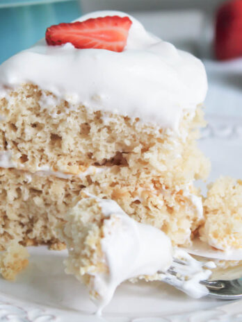A close up of a slice of vegan angel food cake with vegan whipped cream on top.