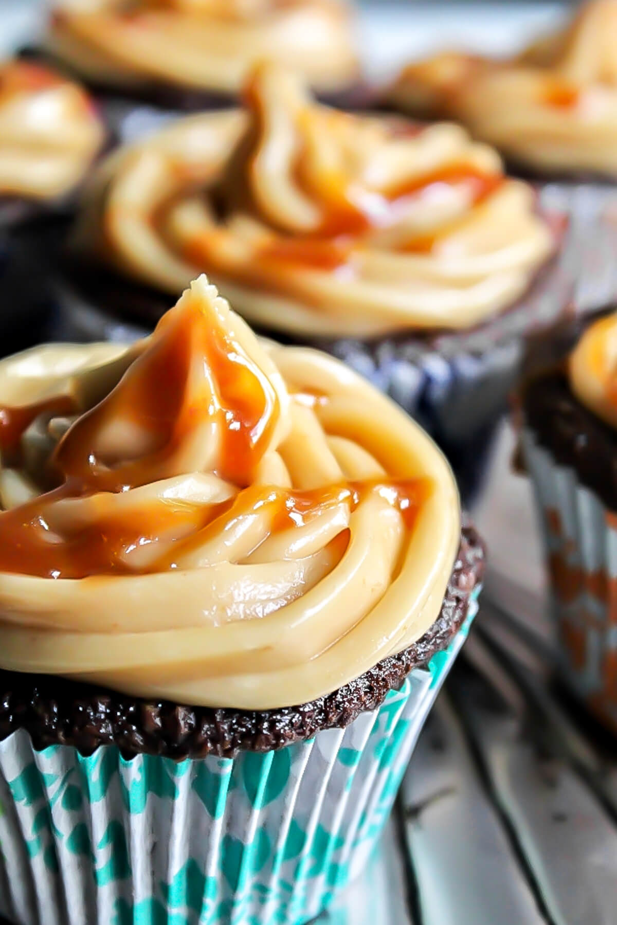 A close up of vegan caramel frosting on a cupcake with salted caramel drizzled on top.
