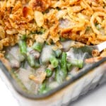 A close up of a vegan green bean casserole with a scoop taken out of it.