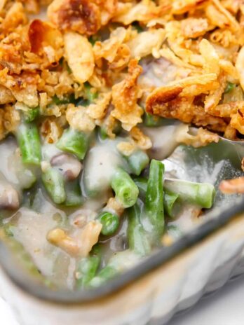 A close up of a vegan green bean casserole with a scoop taken out of it.