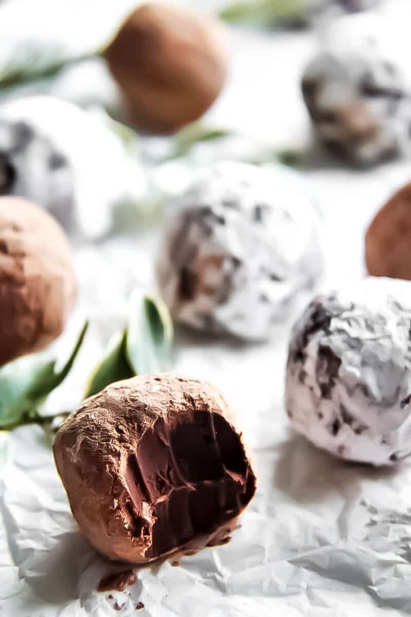 A tray of gluten free vegan chocolate truffles with Kahlua with a bite taken out of one of them.
