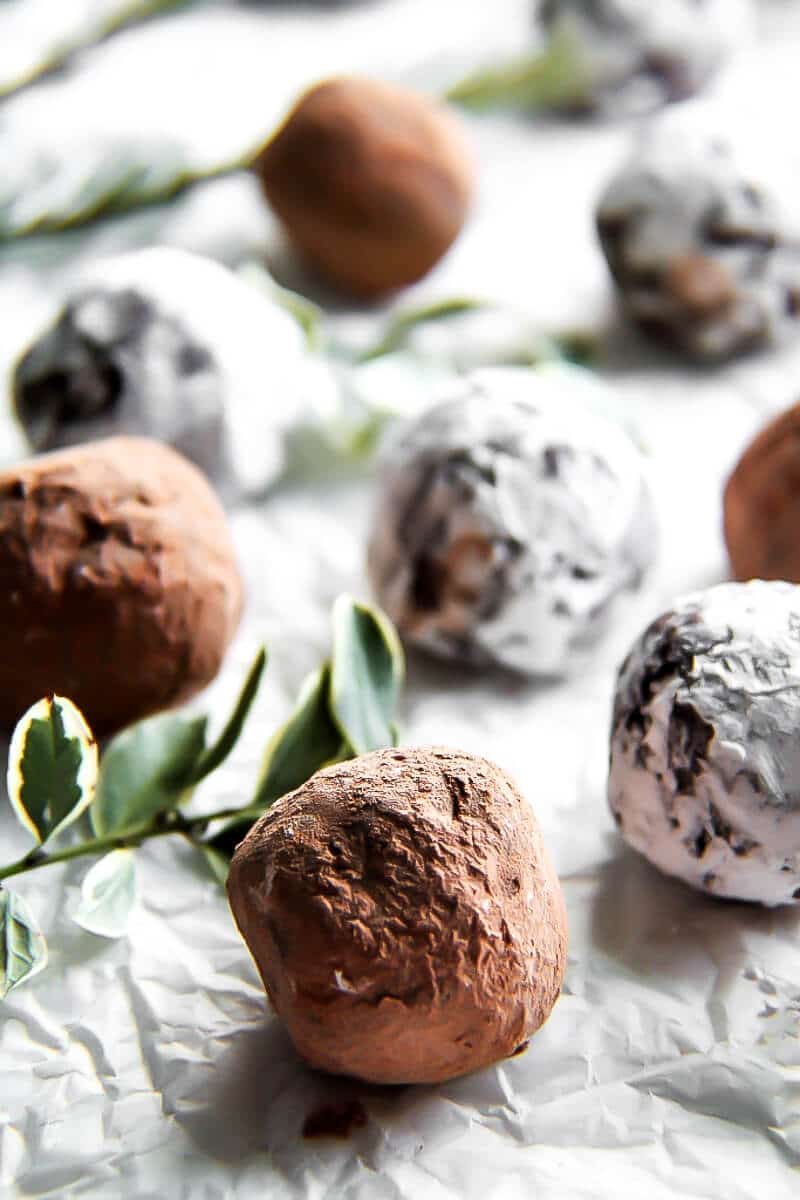 Chocolate truffles with Kahlua rolled in powdered sugar and coco powder on white parchment paper. 