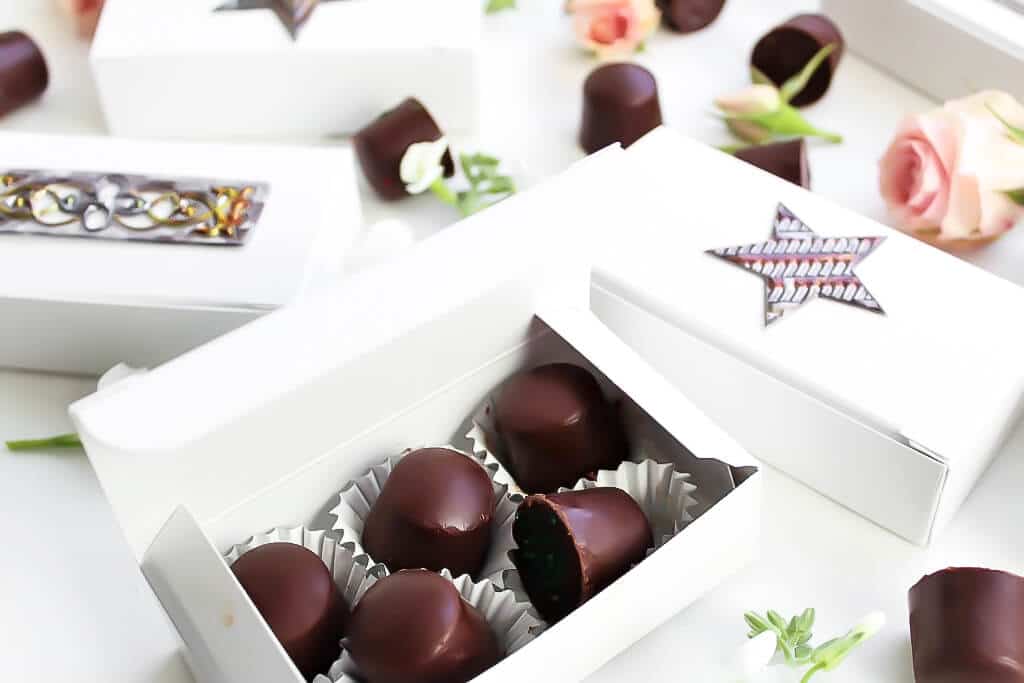 A white candy box filled with homemade chocolates.