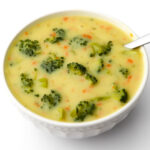 A top view of a white bowl filled with vegan cream of broccoli soup.