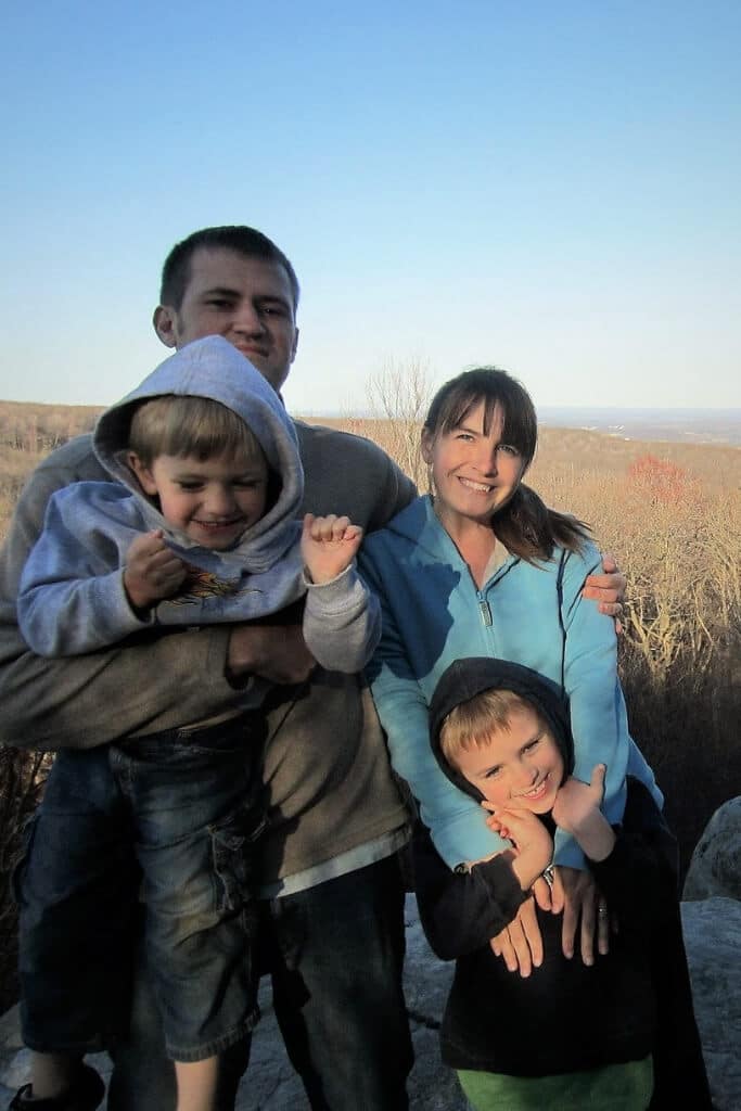 A mother, father, and two vegan boys outside near an overlook.