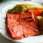 Slices of vegan corned beef made out of tofu on a white plate.