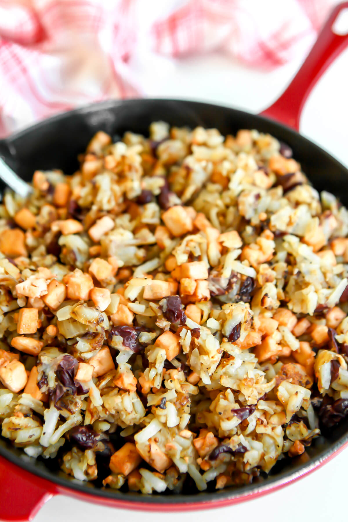 A top view of a red skillet filled with tofu corned beef hash.