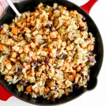 A red iron skillet filled with vegan corned beef hash made with tofu and kidney beans.