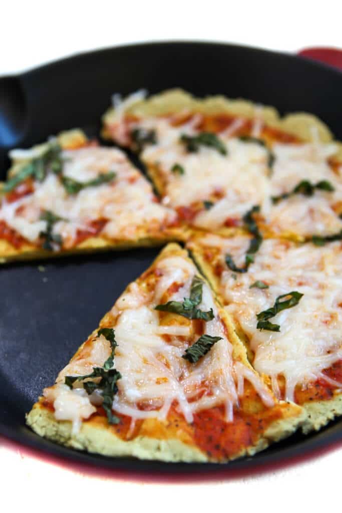 A low carb pizza crust made with tofu in a red iron skillet.