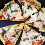 Five slices of low carb high protein pizza crust made with tofu in an iron skillet.