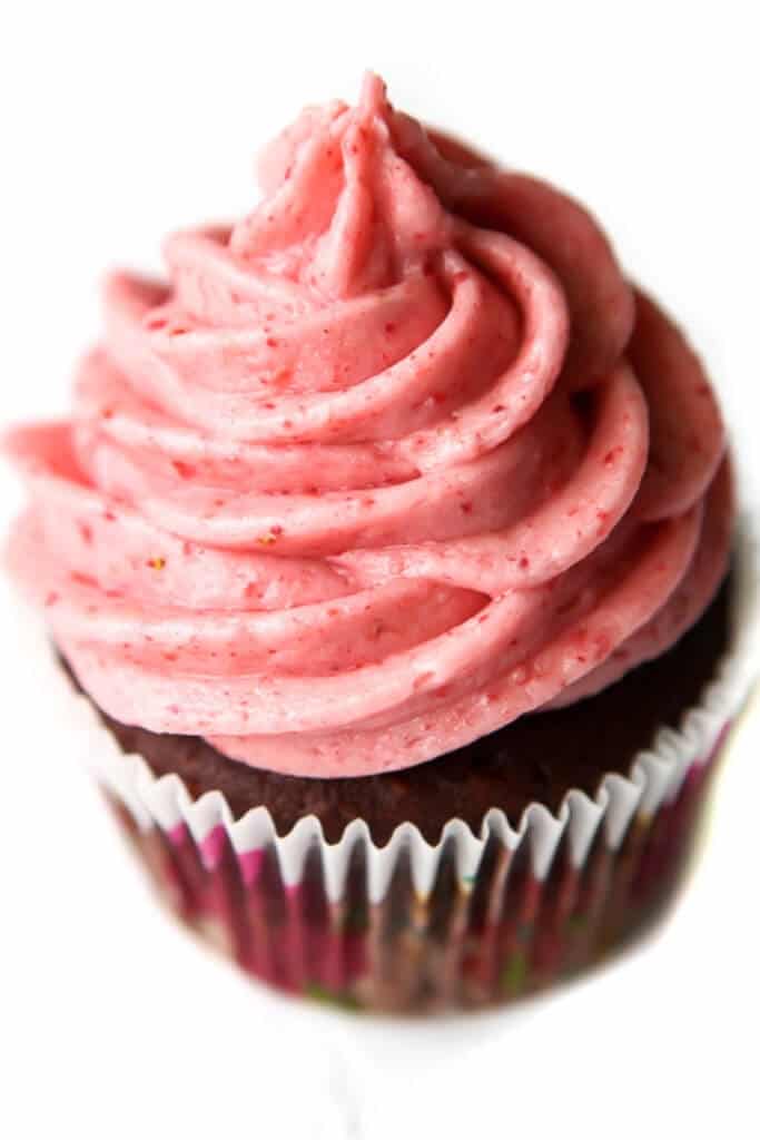 A chocolate cupcake topped with vegan strawberry buttercream